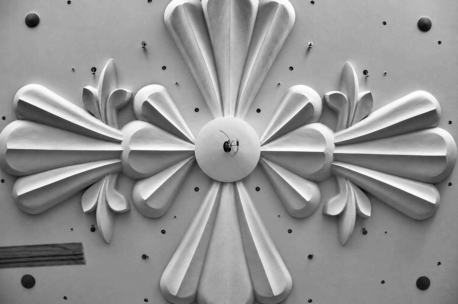 Ornamentales Stuckrelief an einer Decke in sanften Petrol-, Mauve- und Pfirsichtönen